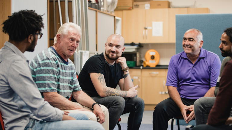 Men support group sitting together in a circle