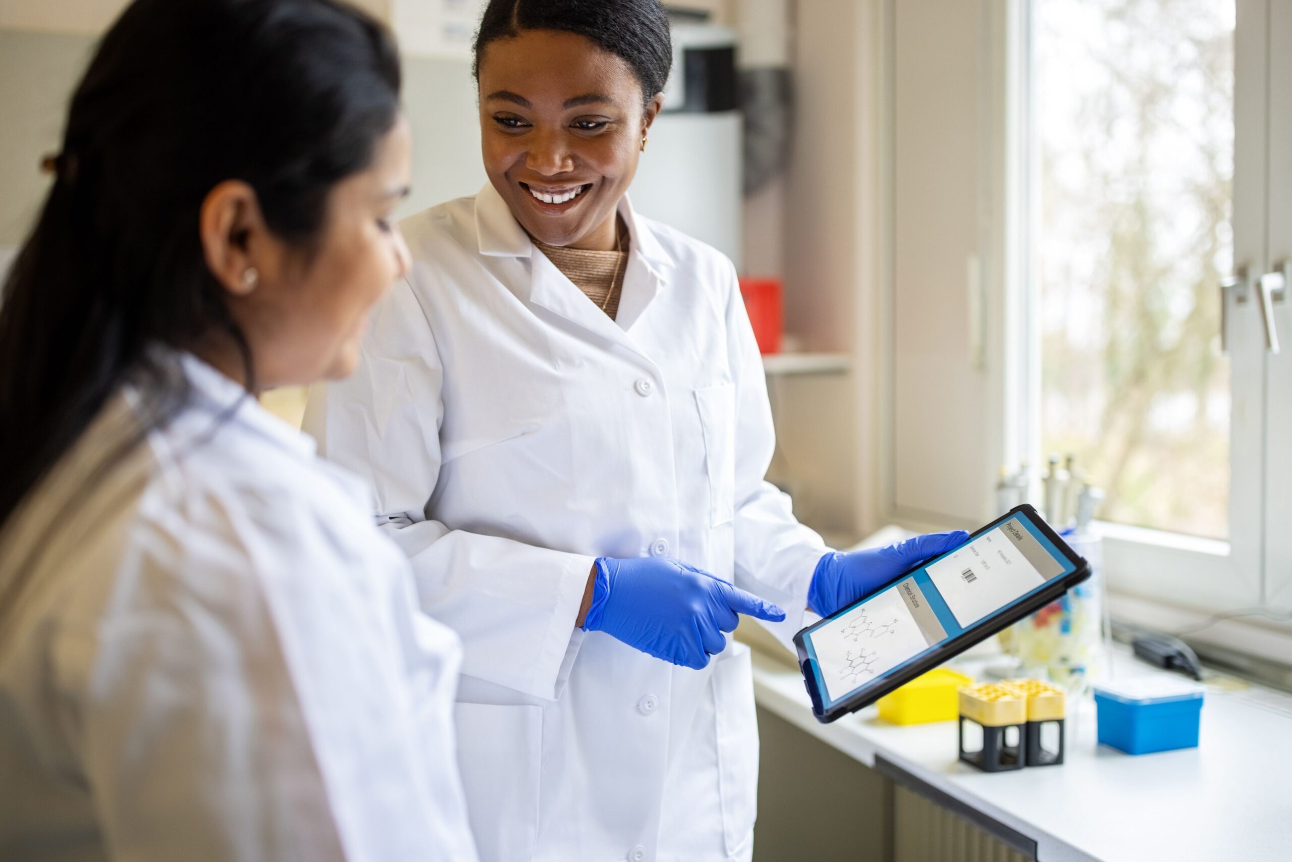 Image of 2 women in a lab looking at a tablet.